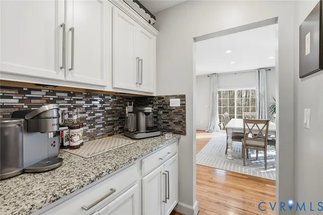 a kitchen with granite countertop white cabinets and white appliances