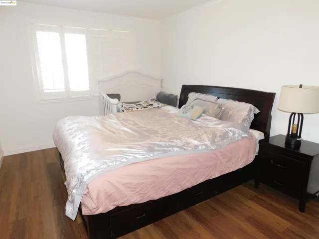a bedroom with a large bed and a wooden floor