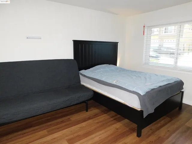 a bedroom with a bed a chair and a window