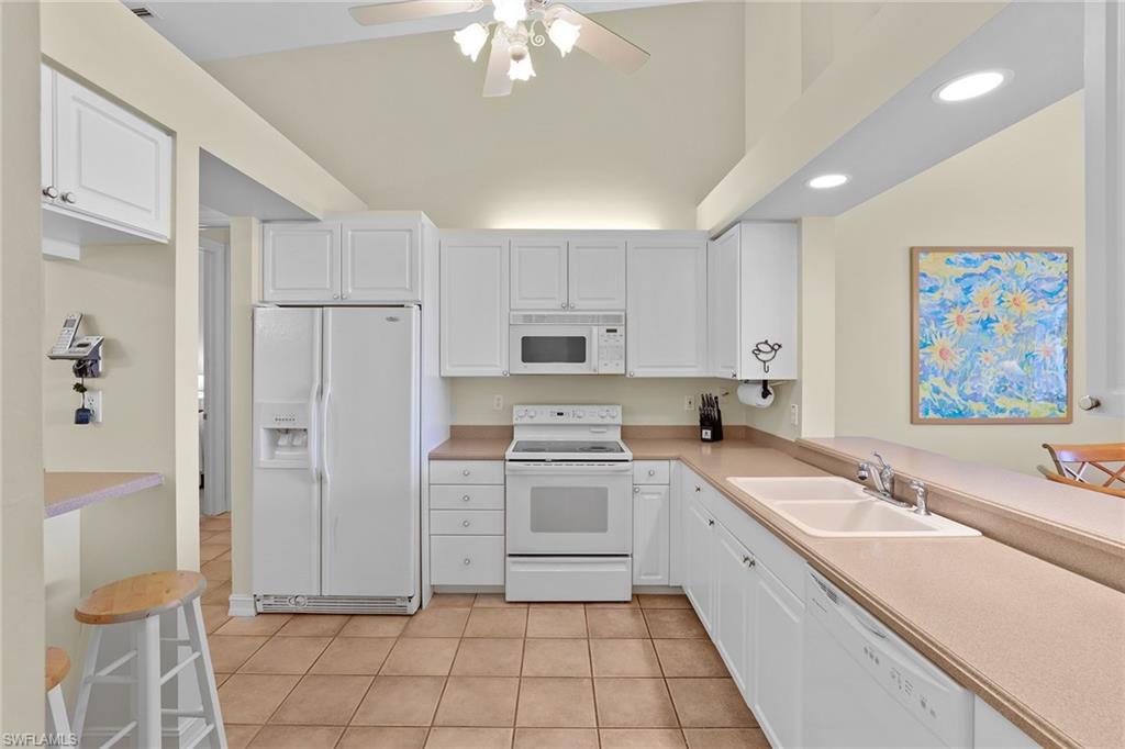 795 Bentwater Circle, Unit 203 Naples, FL 34108 - Photo 11 of 33 a large white kitchen with cabinets