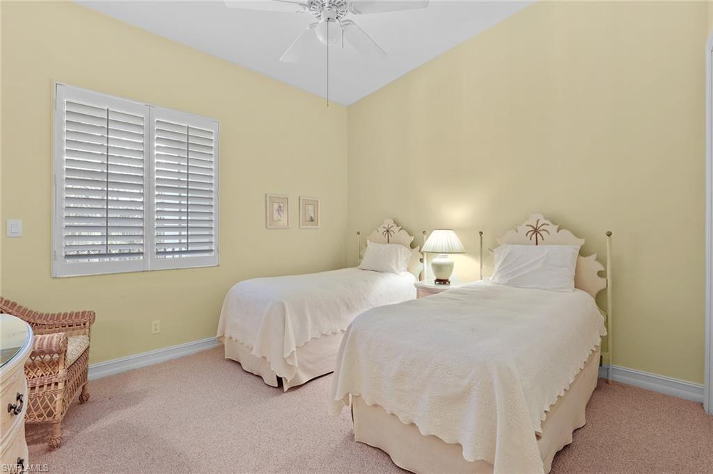 795 Bentwater Circle, Unit 203 Naples, FL 34108 - Photo 13 of 33 a bedroom with two beds and a chandelier