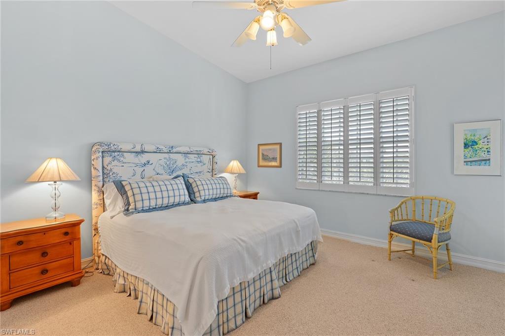 795 Bentwater Circle, Unit 203 Naples, FL 34108 - Photo 14 of 33 a bedroom with a bed and a chandelier