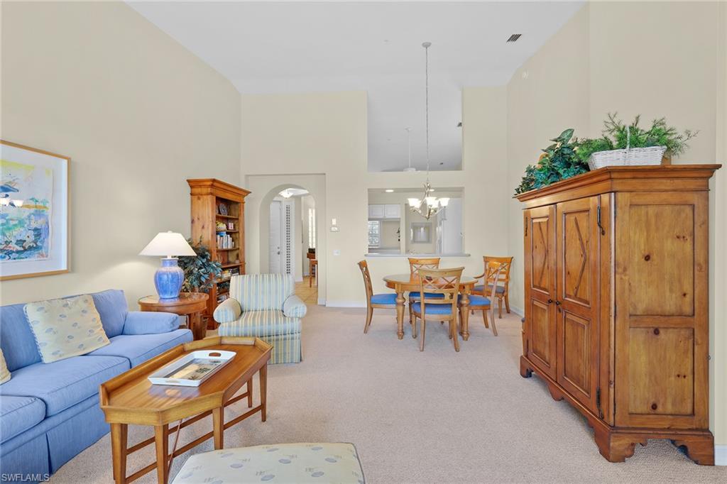 795 Bentwater Circle, Unit 203 Naples, FL 34108 - Photo 9 of 33 a living room with furniture a chandelier and a dining table