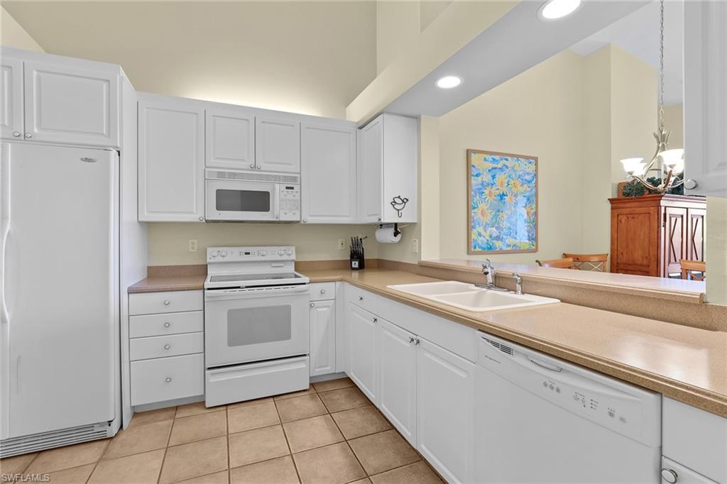 795 Bentwater Circle, Unit 203 Naples, FL 34108 - Photo 10 of 33 a kitchen with a sink cabinets and window