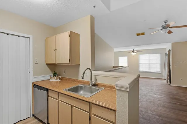 a kitchen with a sink cabinets and wooden floor