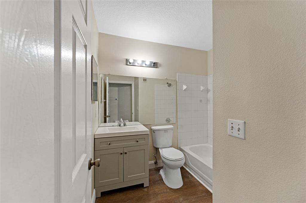 4360 South Kirkman Road, Unit 4 Orlando, FL 32811 - Photo 15 of 21 a bathroom with a toilet a sink and mirror