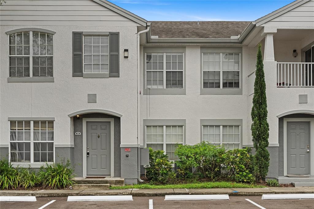 4360 South Kirkman Road, Unit 4 Orlando, FL 32811 - Photo 2 of 21 a front view of a house with a garden and garage
