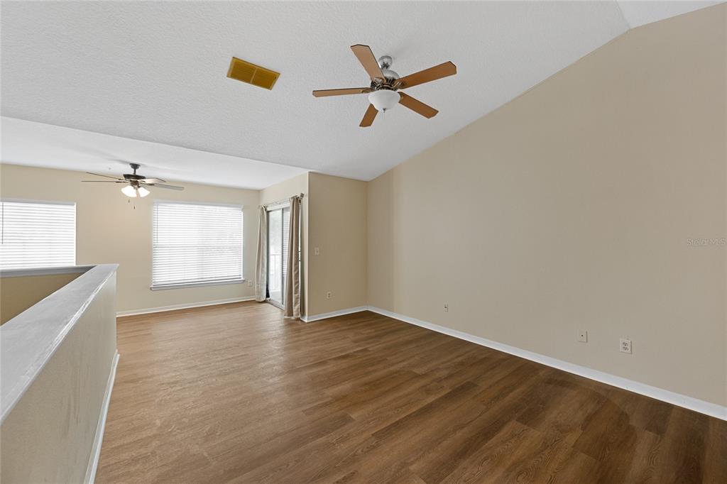 4360 South Kirkman Road, Unit 4 Orlando, FL 32811 - Photo 5 of 21 an empty room with wooden floor fan and windows