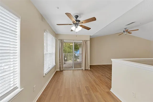 a view of an empty room with a window and wooden floor