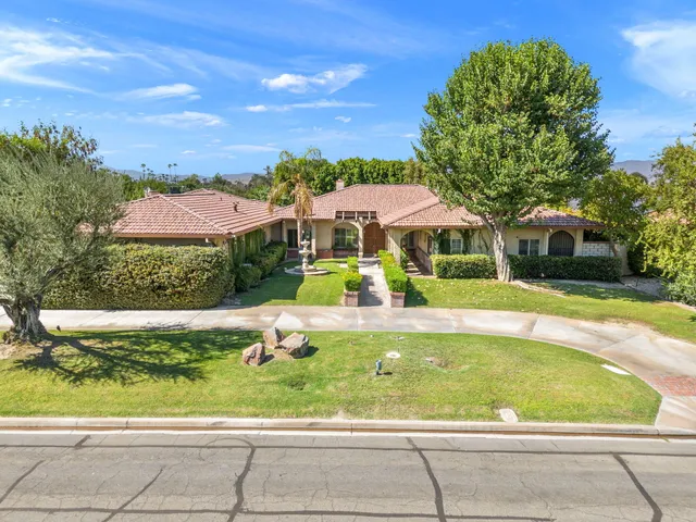 a view of a swimming pool with lawn chairs and plants