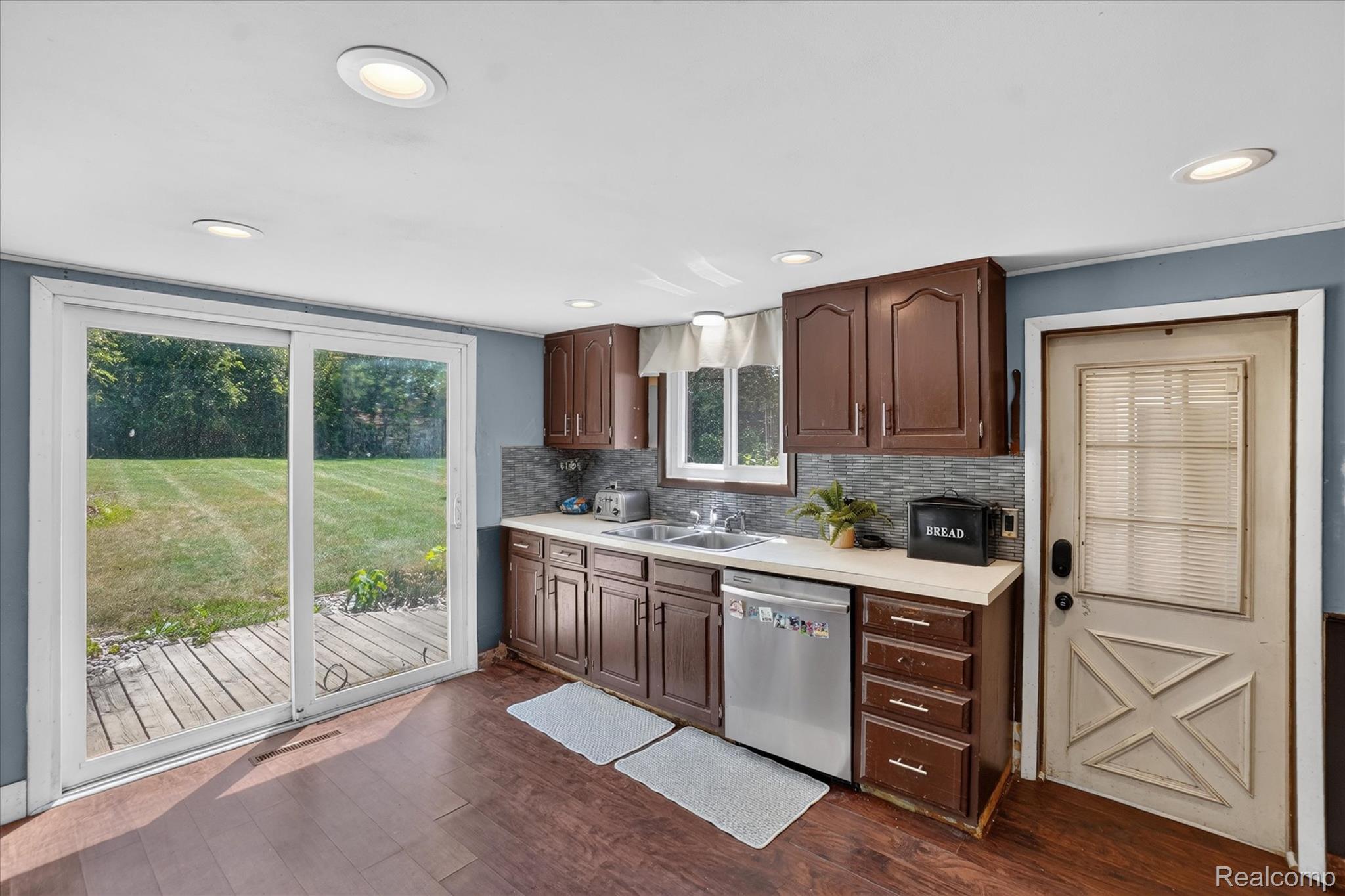 508 Deland Road Flushing, MI 48433 - Photo 16 of 38 Kitchen with wood-finish flooring, recessed lighting, and a sliding glass door opening to a private backyard with a wood deck