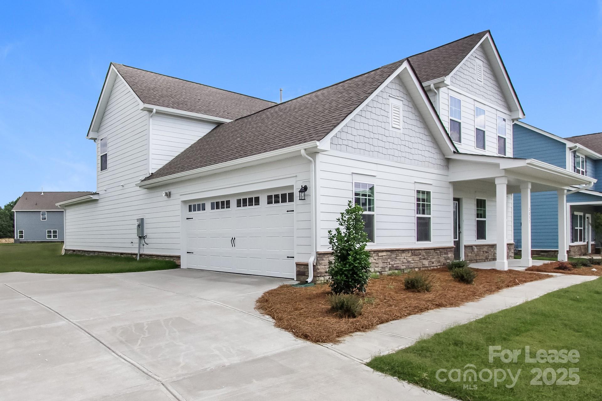 2057 Swanport Lane Monroe, NC 28110 - Photo 13 of 17 a view of a white house next to a yard with potted plants