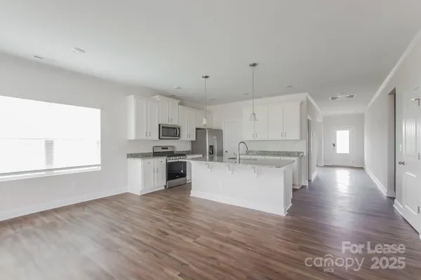 a view of kitchen with wooden floor and electronic appliances