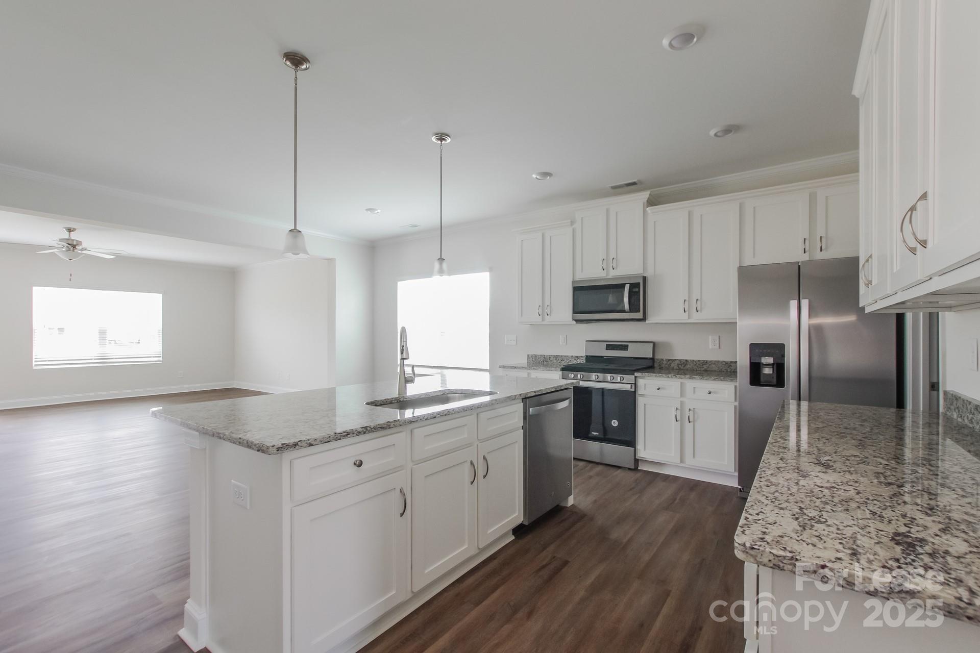 2057 Swanport Lane Monroe, NC 28110 - Photo 5 of 17 a kitchen with granite countertop a sink stainless steel appliances and white cabinets