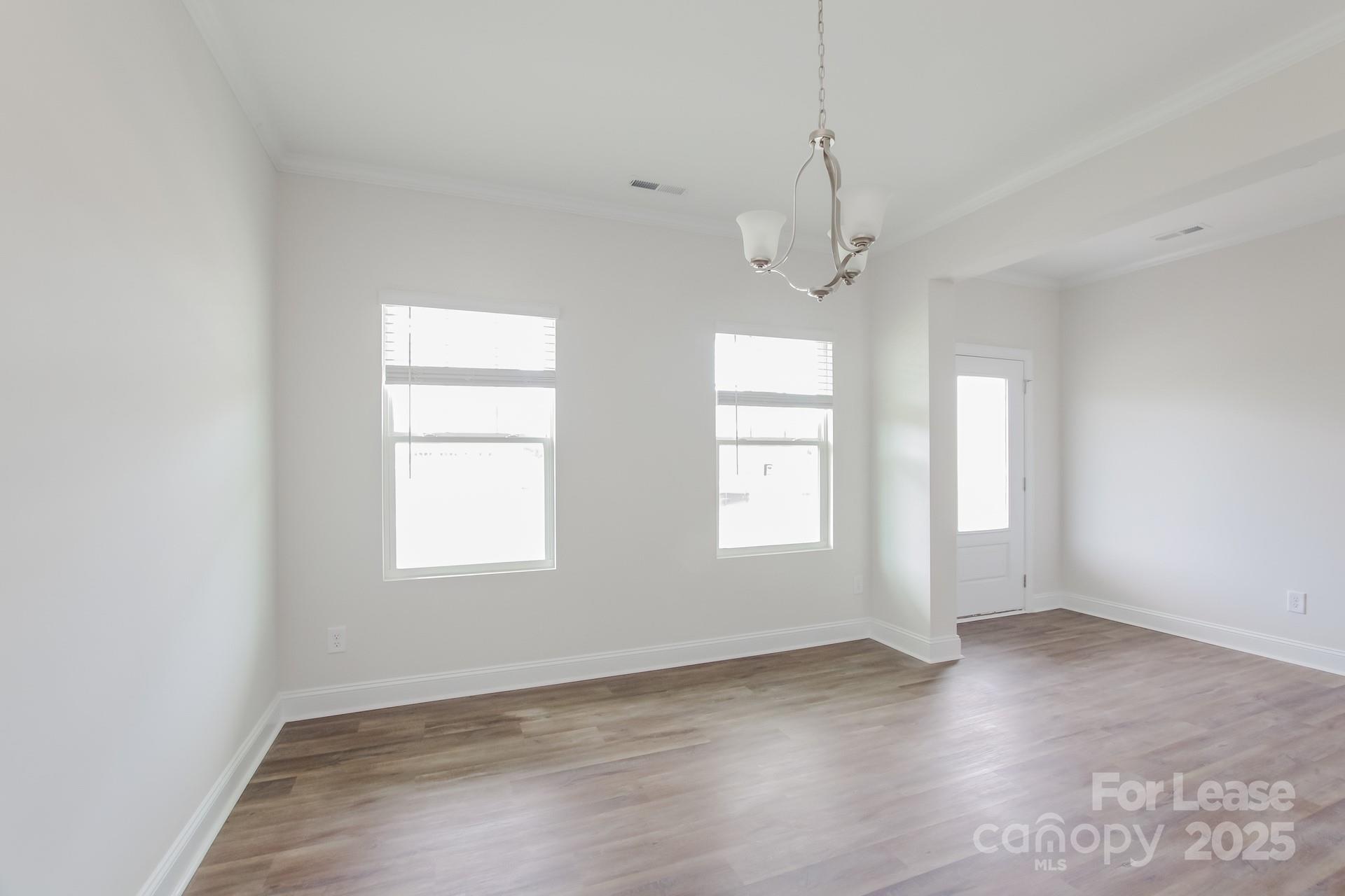 2057 Swanport Lane Monroe, NC 28110 - Photo 7 of 17 an empty room with wooden floor and windows