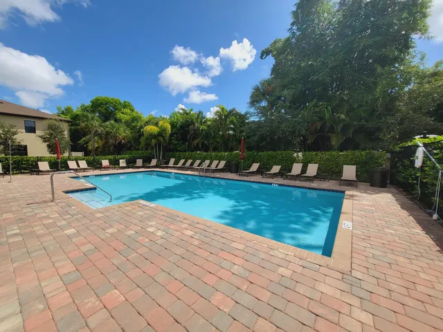 a view of a patio with table and chairs floor to ceiling window and garden