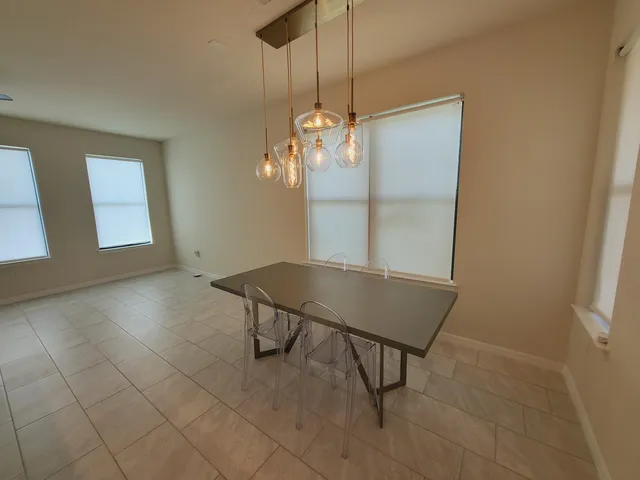a view of a room with a chandelier fan and windows