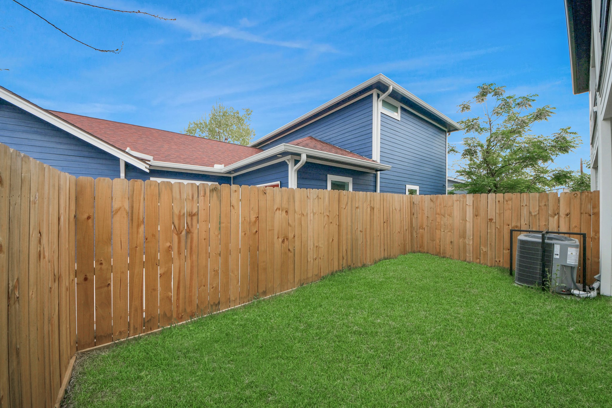 505 Middle Street Houston, TX 77003 - Photo 39 of 46 This cozy backyard offers a private retreat with lush green grass, framed by a charming wooden fence, perfect for relaxing or entertaining.