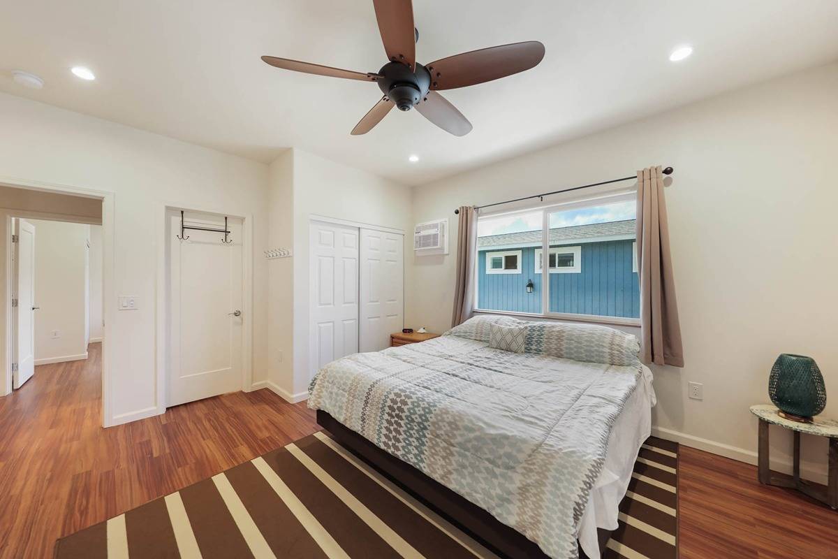 4598 Pueo Road, Unit B Kekaha, HI 96752 - Photo 11 of 27 a bedroom with a bed and wooden floor