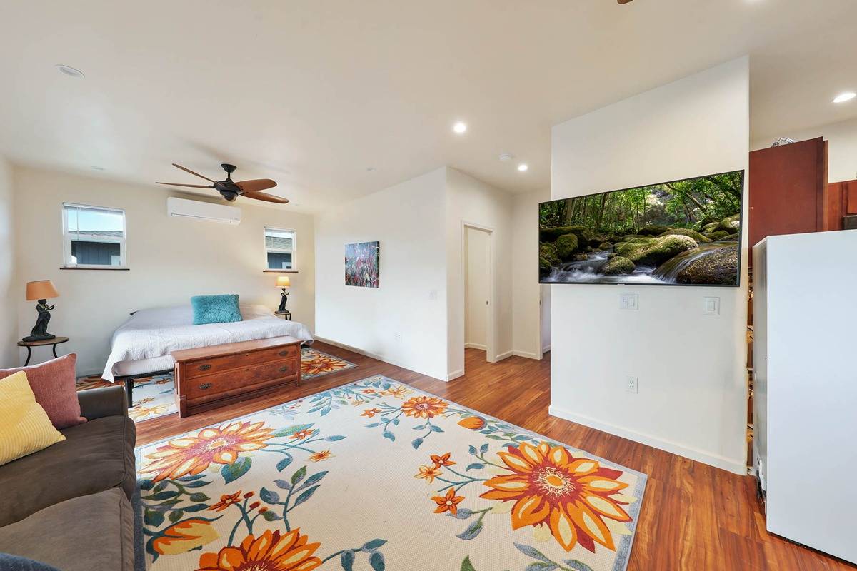 4598 Pueo Road, Unit B Kekaha, HI 96752 - Photo 14 of 27 a bedroom with a bed and a dresser with wooden floor