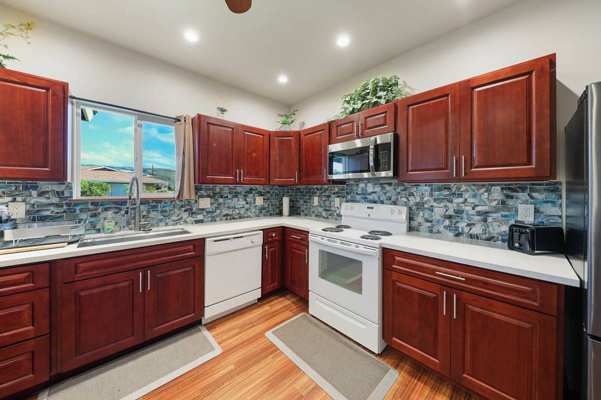4598 Pueo Road, Unit B Kekaha, HI 96752 - Photo 9 of 27 a kitchen with stainless steel appliances granite countertop a sink stove and cabinets