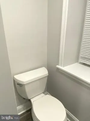 a white toilet sitting next to a window