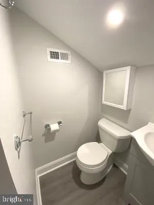 a white toilet sitting next to a bathroom sink and vanity