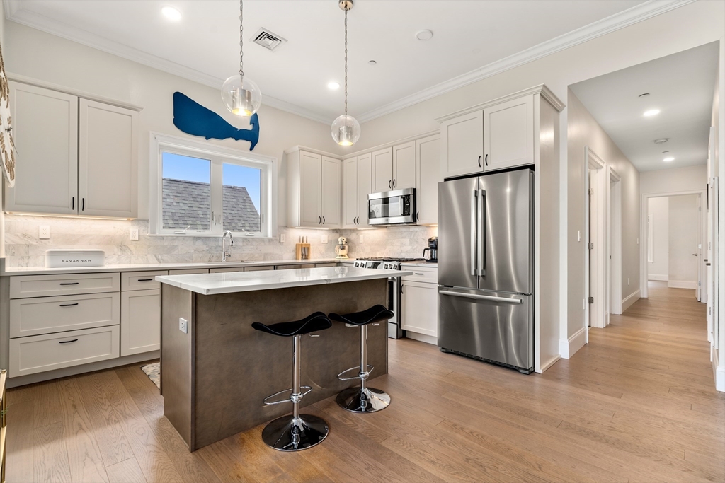 130 Coleridge Street, Unit 6 Boston, MA 02128 - Photo 4 of 26 a kitchen with refrigerator cabinets and wooden floor