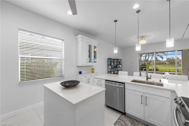 a kitchen with a sink a stove a window cabinets and stainless steel appliances