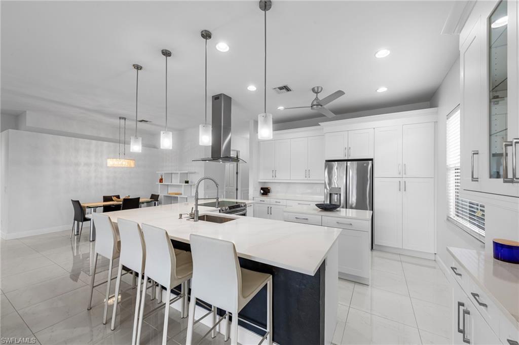 21550 Berwhich Run Estero, FL 33928 - Photo 18 of 50 a kitchen with stainless steel appliances kitchen island granite countertop a sink a stove a refrigerator and white cabinets with wooden floor