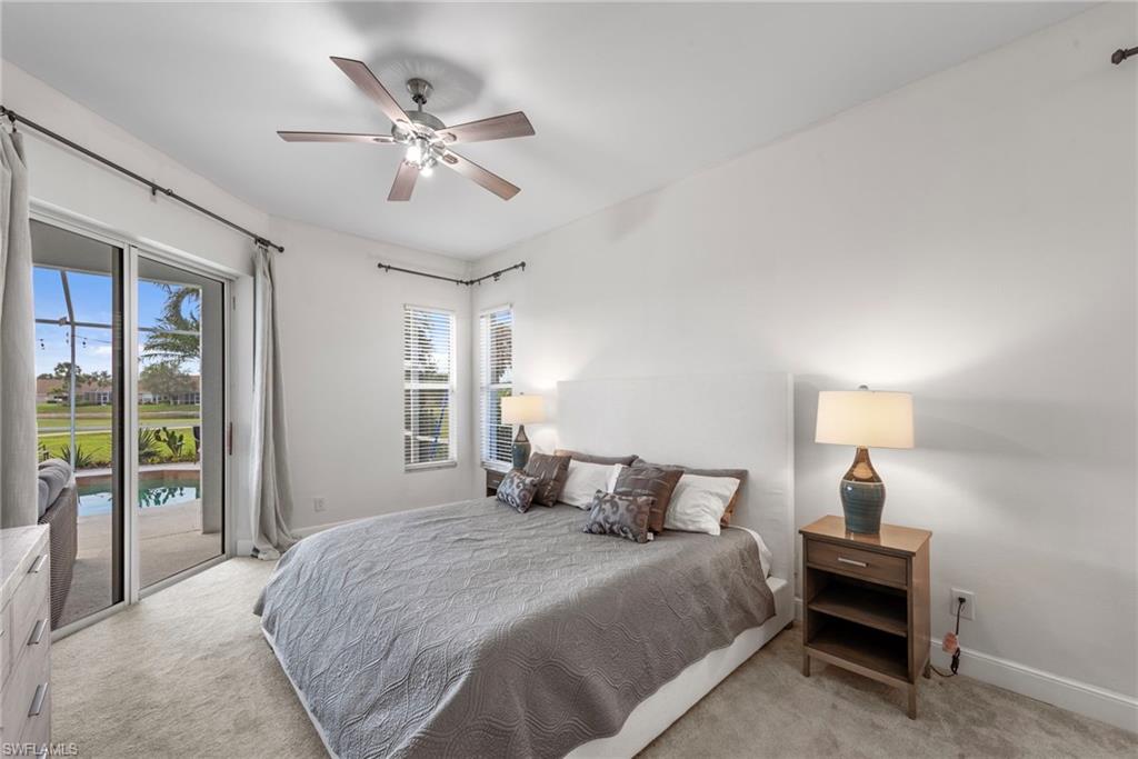 21550 Berwhich Run Estero, FL 33928 - Photo 21 of 50 a bedroom with a large bed and a chandelier