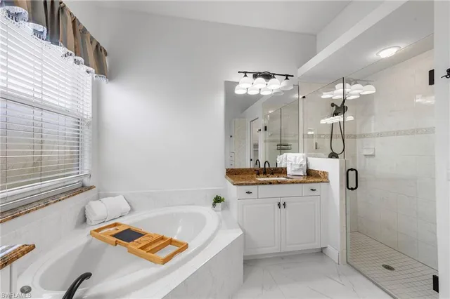 a bathroom with a tub sink and mirror