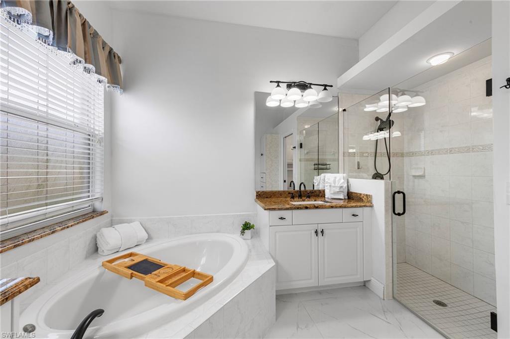 21550 Berwhich Run Estero, FL 33928 - Photo 25 of 50 a bathroom with a tub sink and mirror