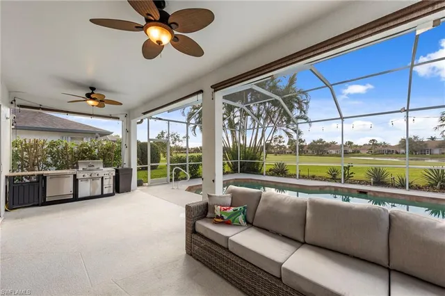 a living room with couch floor to ceiling window and outer view