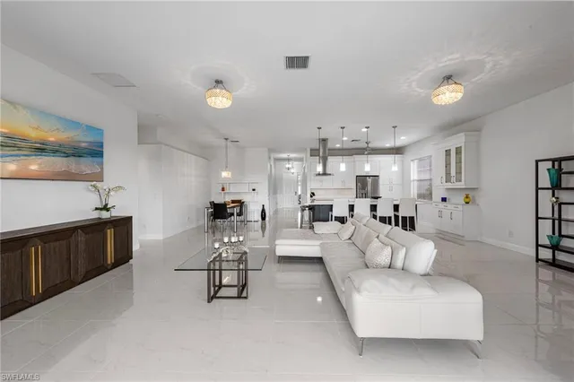 a living room with furniture and a refrigerator