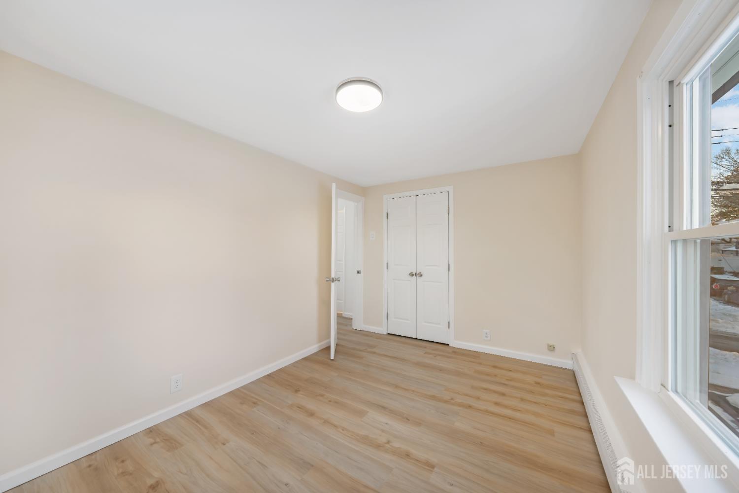 25 Dane Street Sayreville, NJ 08872 - Photo 14 of 31 a view of an empty room with wooden floor and a window