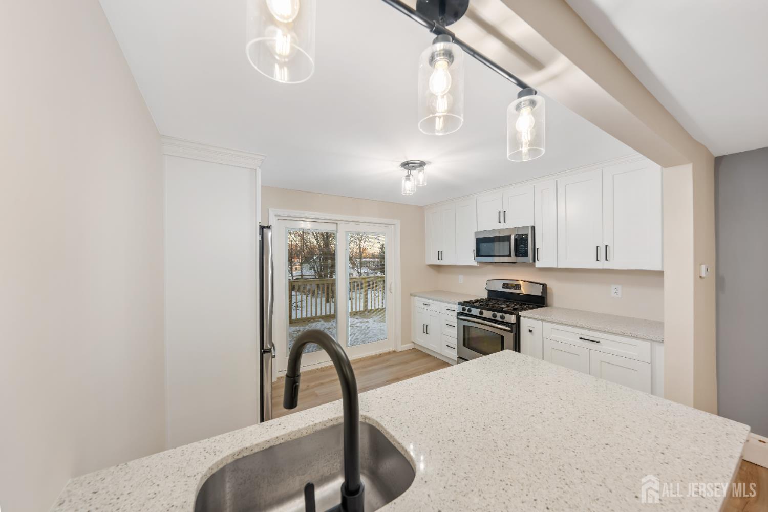 25 Dane Street Sayreville, NJ 08872 - Photo 9 of 31 a kitchen with stainless steel appliances a stove a sink dishwasher a oven with a dining table and chairs
