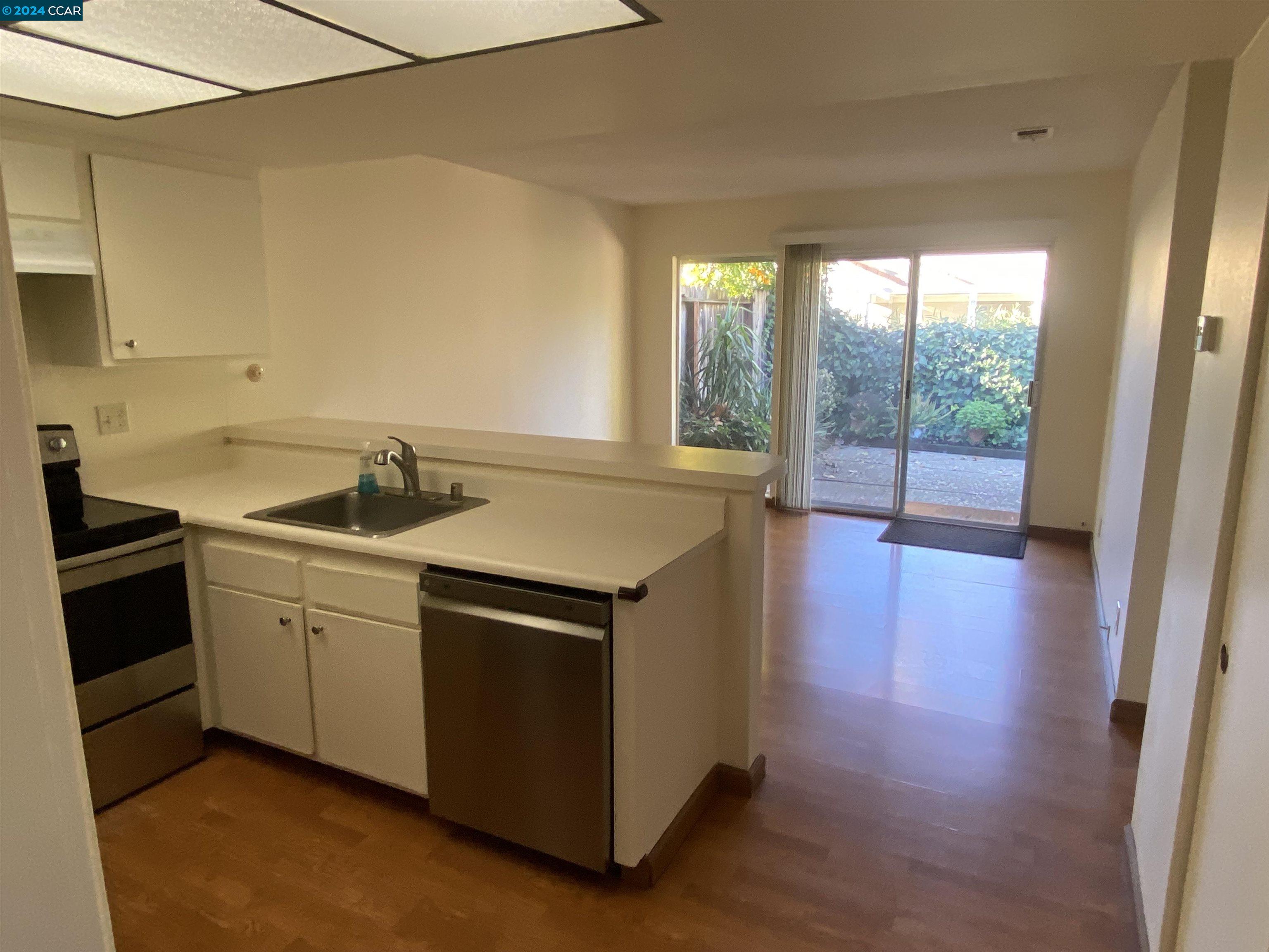 506 Tampico Walnut Creek, CA 94598 - Photo 7 of 32 a view of a kitchen with a sink and dishwasher with wooden floor