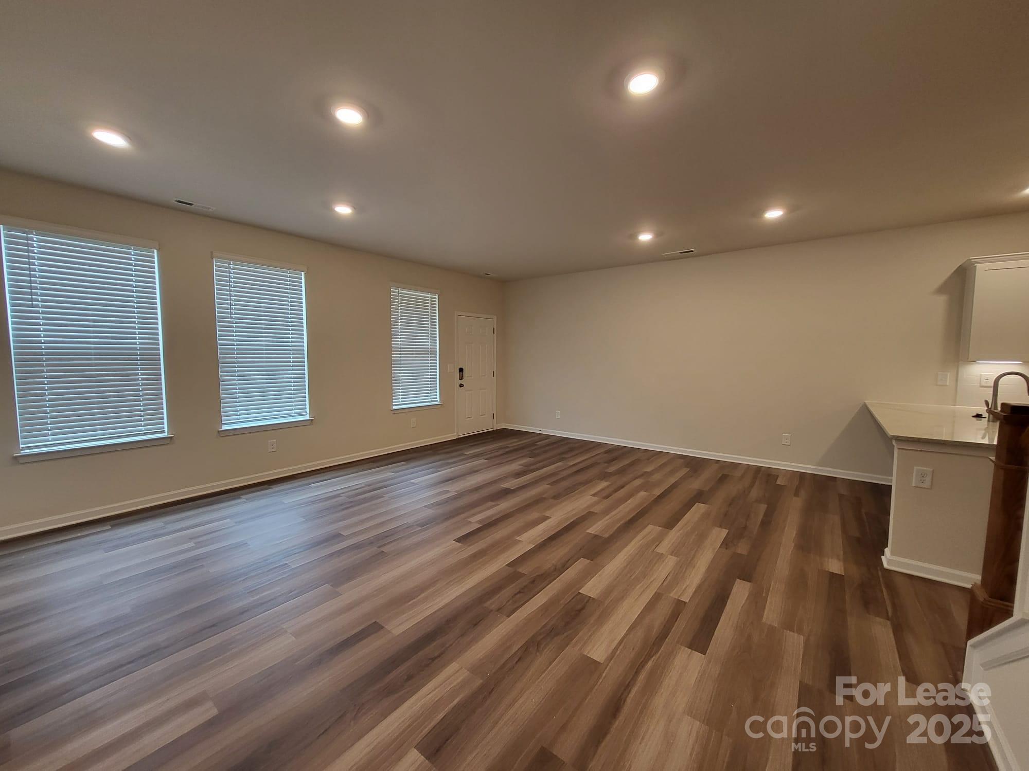 3511 Glenn Hope Way Matthews, NC 28104 - Photo 6 of 17 an empty room with wooden floor and windows