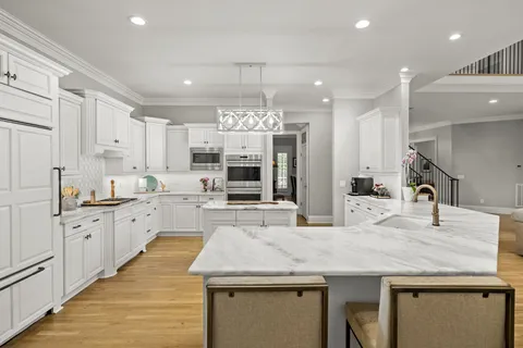 a large kitchen with granite countertop lots of counter space sink and appliances