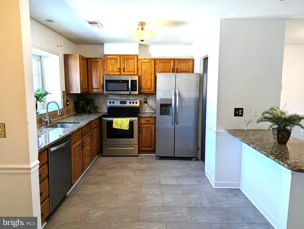 a kitchen with stainless steel appliances granite countertop a refrigerator and a sink