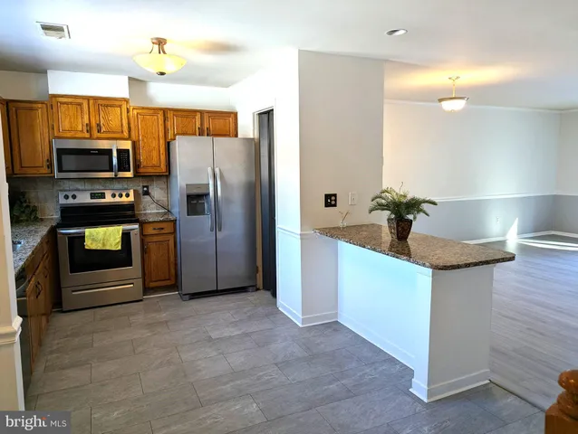 a kitchen with stainless steel appliances granite countertop a refrigerator and a sink