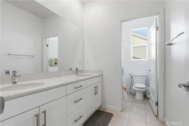 a bathroom with a granite countertop toilet sink and mirror