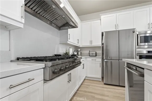 a kitchen with stainless steel appliances granite countertop a stove a refrigerator and a refrigerator