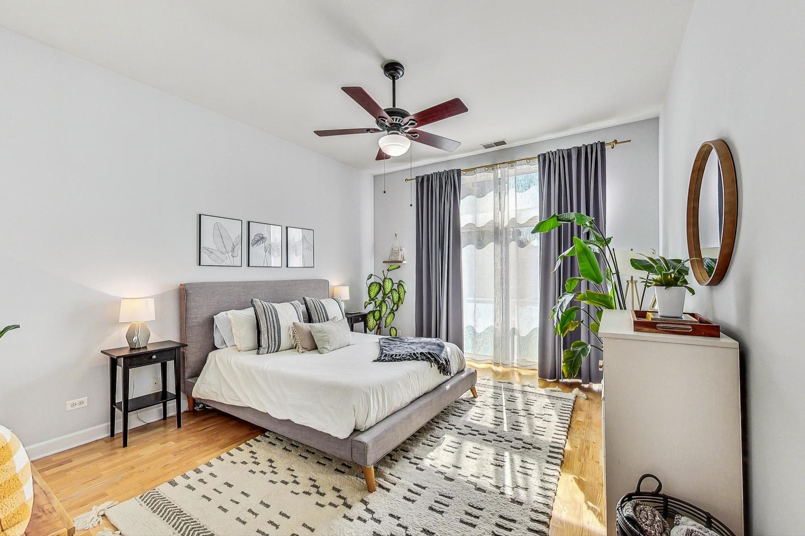 4150 North Sheridan Road, Unit 2S Chicago, IL 60613 - Photo 15 of 29 a bedroom with a bed wooden floor and a table