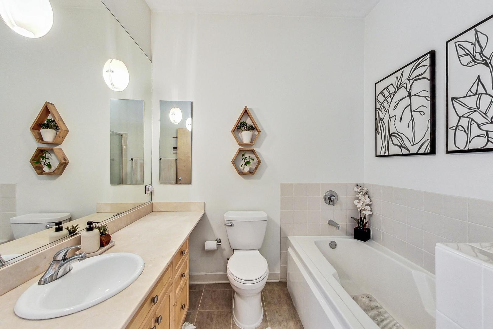 4150 North Sheridan Road, Unit 2S Chicago, IL 60613 - Photo 19 of 29 a bathroom with a sink a toilet and a mirror