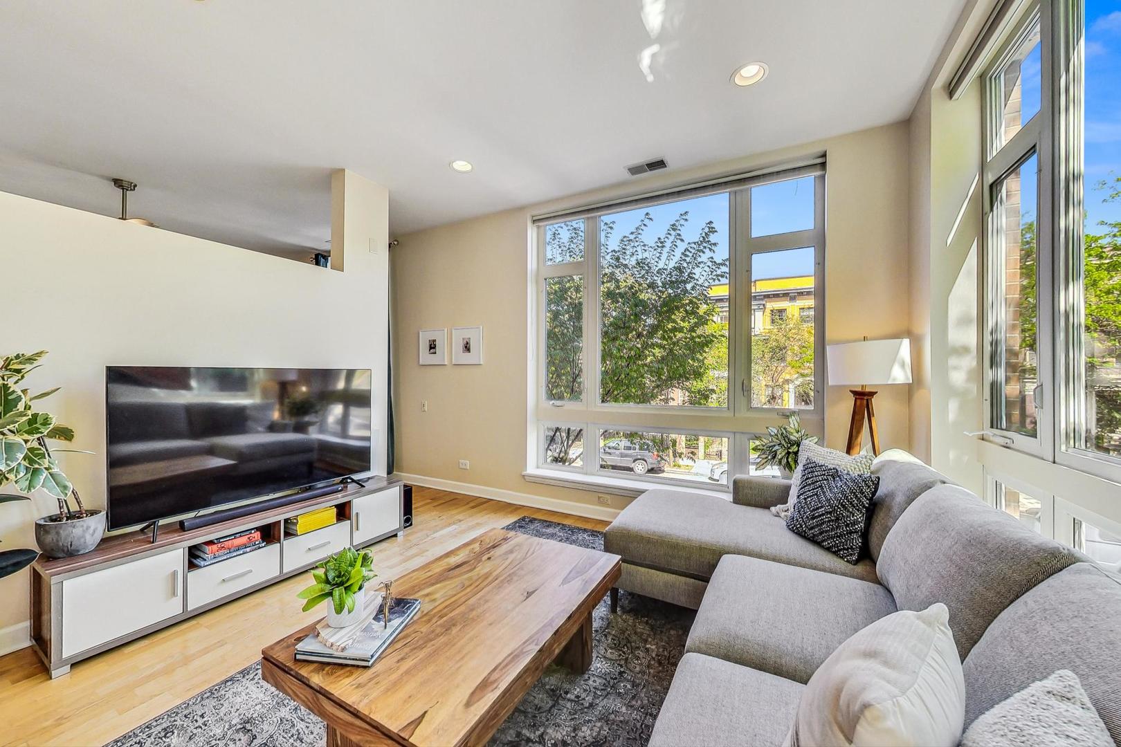 4150 North Sheridan Road, Unit 2S Chicago, IL 60613 - Photo 5 of 29 a living room with furniture a flat screen tv and a large window