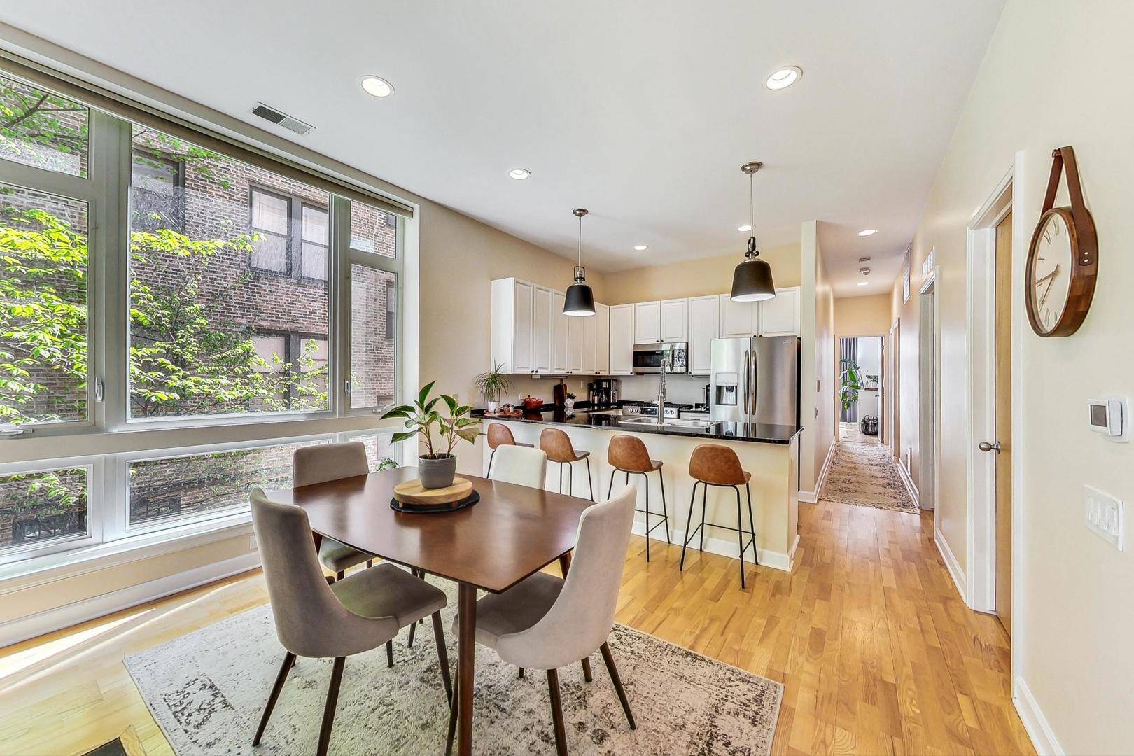 4150 North Sheridan Road, Unit 2S Chicago, IL 60613 - Photo 8 of 29 a dining room with stainless steel appliances granite countertop a table and chairs