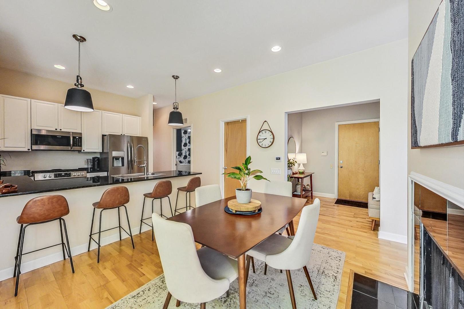 4150 North Sheridan Road, Unit 2S Chicago, IL 60613 - Photo 10 of 29 a kitchen with stainless steel appliances granite countertop a table chairs and a refrigerator