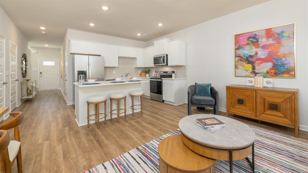 2082 Moss Hill Road Stone Mountain, GA 30083 - Photo 19 of 38 a living room with stainless steel appliances furniture a rug and a kitchen view